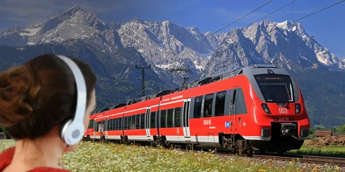 DB Regio Zug vor Bergpanorama mit Frau mit Kopfhörern